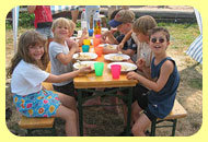 Kinder beim gemeinsamen Essen im Freien