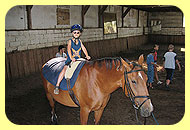 Kind sitzt auf einem Pferd