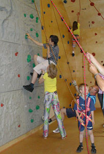 Kinder klettern an der Kletterwand