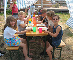 Kinder beim gemeinsamen Essen im Freien